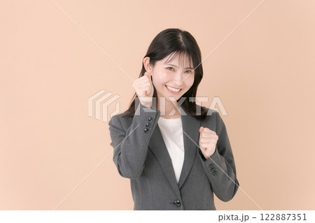 ガッツポーズをする笑顔の若いビジネスウーマン ガッツポーズをする笑顔の若いビジネスウーマン 122887351