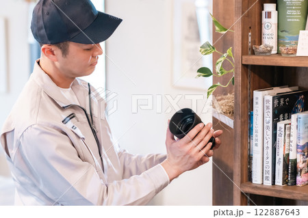 リビングにあるカメラレンズの査定をする男性専門業者 122887643