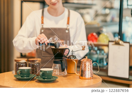 コーヒー豆を準備する若い女性店員　顔無し 122887656