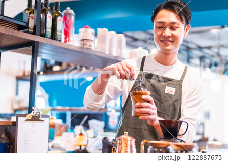 おしゃれなカフェでコーヒーを淹れる男性店員 おしゃれなカフェでコーヒーを淹れる男性店員 122887673