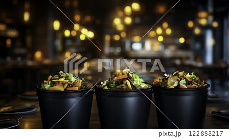 Overflowing Trash Bins in Restaurant Kitchen Setting with Low Light 122888217