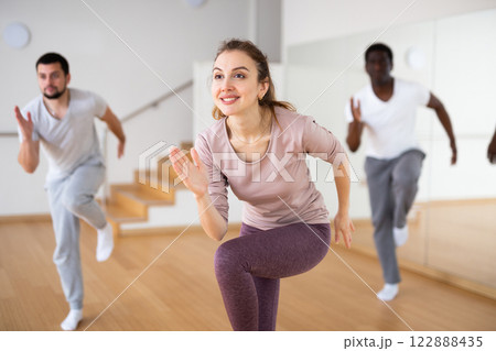 Cheerful woman dancing aerobic dance during group training Cheerful woman dancing aerobic dance during group training 122888435