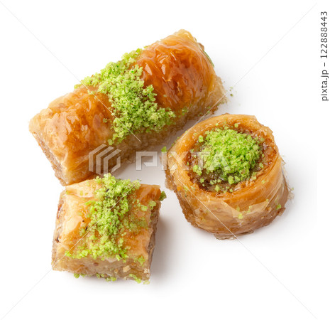 Delicious traditional dessert featuring flaky pastry and nut filling served with a sweet syrup 122888443
