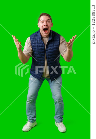 Man celebrating with raised fists in front of a bright green background Man celebrating with raised fists in front of a bright green background 122888513