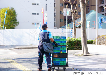 台車で荷物を運ぶ配達員 122889115