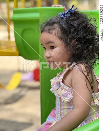 Little Asian girl playing on playground in public park, Thailand 122889293