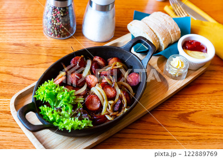 Grilled sausages with onions Grilled sausages with onions 122889769