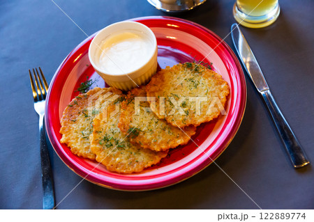 Fried grated potato pancakes with sour cream Fried grated potato pancakes with sour cream 122889774
