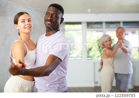Men and women of different ages practicing Ballroom dances in training room 122889785
