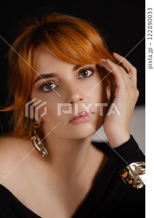 Close-up portrait of a young woman with bright red hair 122890033