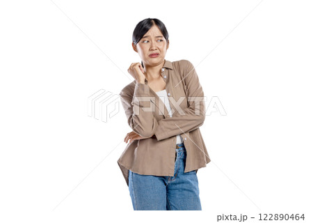Portrait of an Asian Woman in a shirt with a disliked expression isolated over a white background. The gesture prevents or avoid Portrait of an Asian Woman in a shirt with a disliked expression isolated over a white background. The gesture prevents or avoid 122890464