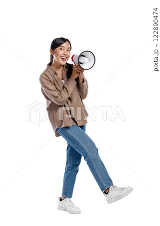Portrait of an Asian Indonesian Woman in a shirt talking on a megaphone isolated over a white background. Concept of communication Portrait of an Asian Indonesian Woman in a shirt talking on a megaphone isolated over a white background. Concept of communication 122890474