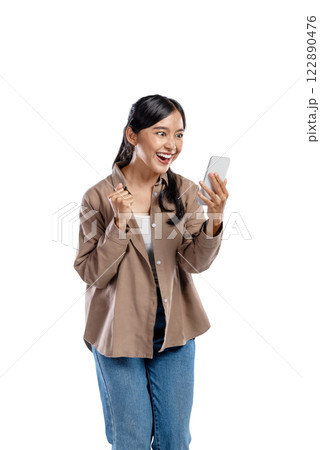 Portrait of an Asian Indonesian Woman in a shirt with a happy expression holding a mobile phone isolated over a white background. Concept of technology Portrait of an Asian Indonesian Woman in a shirt with a happy expression holding a mobile phone isolated over a white background. Concept of technology 122890476
