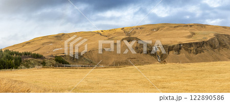 Panoramic view of meadow field with mountain range landscape in Iceland Panoramic view of meadow field with mountain range landscape in Iceland 122890586