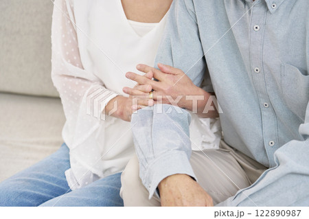 腕を組むシニアの夫婦　リビング　顔無し 122890987