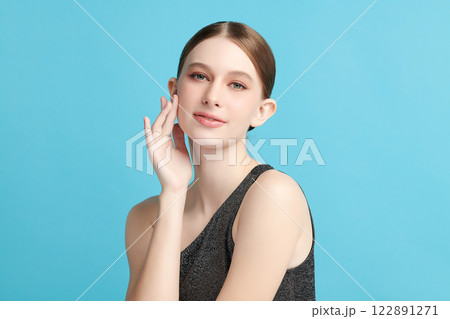 Beautiful young woman with clean fresh skin on blue background, Face care, Facial treatment, Cosmetology, beauty and spa, women portrait. Beautiful young woman with clean fresh skin on blue background, Face care, Facial treatment, Cosmetology, beauty and spa, women portrait. 122891271