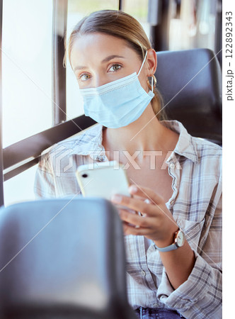 Woman, covid and phone in travel bus for health safety, news and social media with mask. Portrait of a female traveler in public transport during pandemic on mobile smartphone for communication 122892343