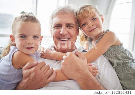 Family, love and hug for grandpa from children while sitting together for a relationship portrait, smile and bonding at home. Happy girl kids or twin sisters with a senior man having fun and playing Family, love and hug for grandpa from children while sitting together for a relationship portrait, smile and bonding at home. Happy girl kids or twin sisters with a senior man having fun and playing 122892431