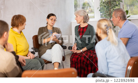 Young girl conducting language club for group of older adults Young girl conducting language club for group of older adults 122892698