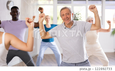 Mature men and women practicing Hip-hop dance in training hall Mature men and women practicing Hip-hop dance in training hall 122892733