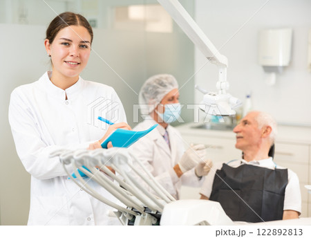 Young woman nurse with paper is standing in dental office, clinic 122892813