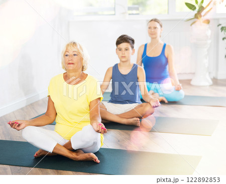 Group of people generation on mats doing yoga exercise lord of fishes pose. Group of people generation on mats doing yoga exercise lord of fishes pose. 122892853