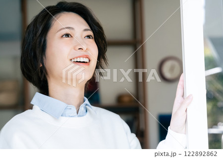 リビングから外を見る女性 122892862