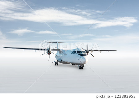 White passenger turboprop plane isolated on bright background with sky 122892955