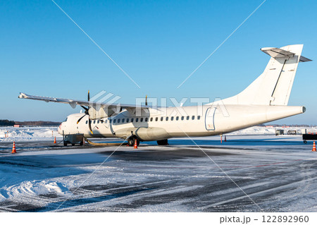 White passenger turboprop aircraft on the winter airport 122892960
