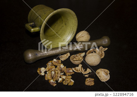 Ancient mortar and chopped walnuts 122894716
