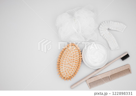 Flat lay of bath essentials. Wooden brush, cream, toothbrush, comb, and exfoliating pads Flat lay of bath essentials. Wooden brush, cream, toothbrush, comb, and exfoliating pads 122898331