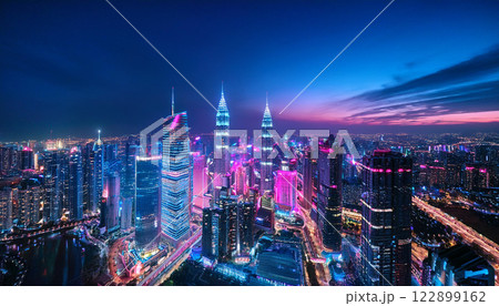 A city skyline at night with neon lights and a purple sky 122899162