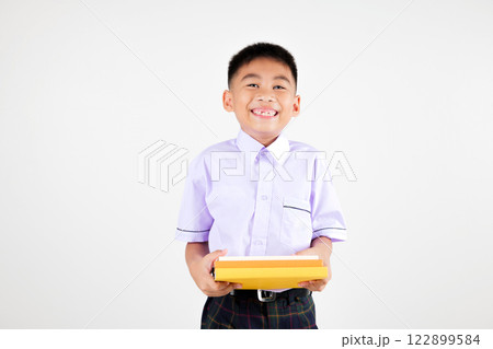 Portrait smile Asian little boy primary posing hand holding book studio isolated white background, happy cute man kid wear school uniform plaid, back to school concept 122899584