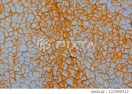 Abstract texture of cracked surface with rusty orange cracks on light background.Texture of metal sheet. Abstract texture of cracked surface with rusty orange cracks on light background.Texture of metal sheet. 122900412