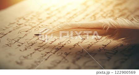 White feather quill resting on antique handwritten document 122900569