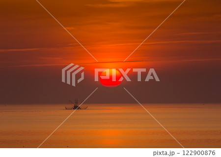 Lonely fishing boat with trawl in the North Sea at sunset 122900876