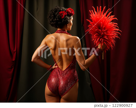 Burlesque dancer holding red feather boa on stage Burlesque dancer holding red feather boa on stage 122900927