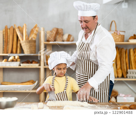 Father and daughter roll out dough together to make delicious bread Father and daughter roll out dough together to make delicious bread 122901488