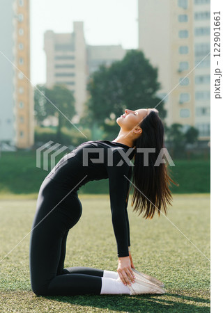 Focused Woman Practicing Yoga Outdoors 122901661