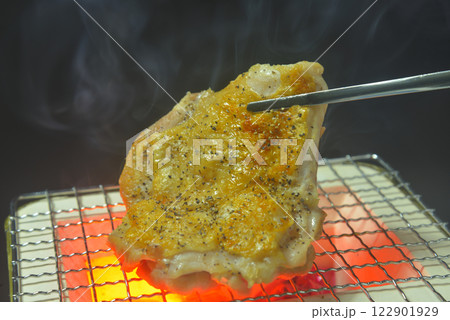 煙り立ち昇る七輪で鶏もも肉を焼く 122901929