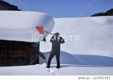 豪雪地帯で雪下ろしをする老人 豪雪地帯で雪下ろしをする老人 122901933