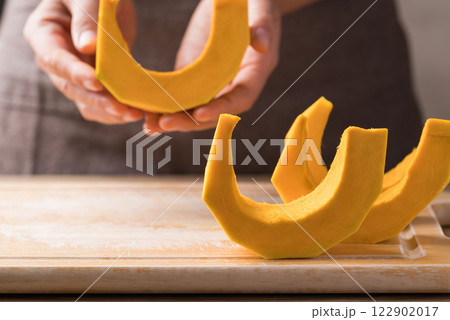 Section and peeled pumpkin holding by hand, Homemade cooking Section and peeled pumpkin holding by hand, Homemade cooking 122902017