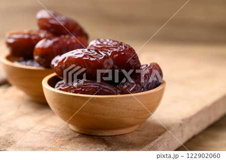 Date palm fruit (MedJool) in wooden bowl 122902060