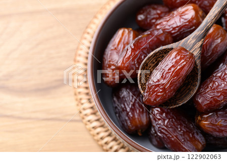 Date palm fruit (MedJool) in bowl with spoon, Top view 122902063