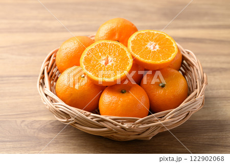 Mandarin tangerine orange fruit in basket on wooden background Mandarin tangerine orange fruit in basket on wooden background 122902068