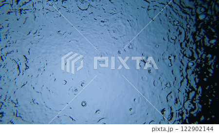 Raindrops falling on water surface creating concentric circles 122902144
