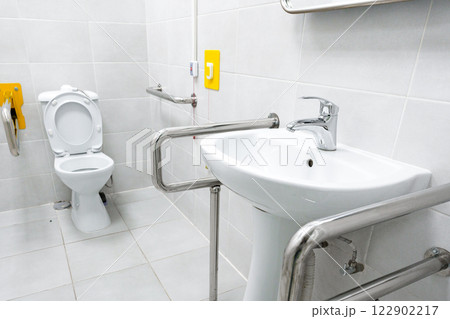 Accessible restroom featuring grab bars and modern fixtures for inclusive use 122902217