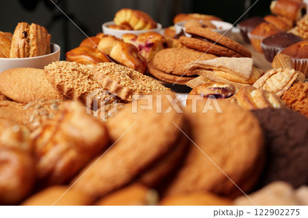 Baked goods displayed on a table featuring various cookies and pastries in a cozy setting Baked goods displayed on a table featuring various cookies and pastries in a cozy setting 122902275