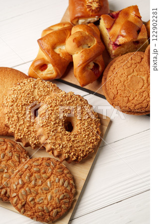 Freshly baked cookies and pastries on a wooden platter in a cozy kitchen setting Freshly baked cookies and pastries on a wooden platter in a cozy kitchen setting 122902281