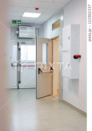 Interior hallway of a modern medical facility with a door leading to a treatment area in daylight 122902337